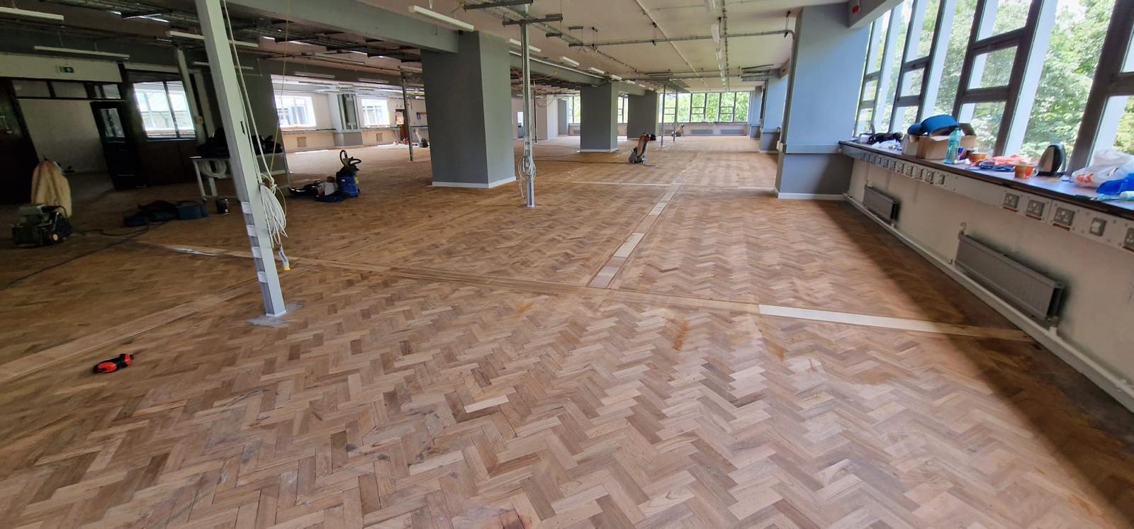 Cambridge school herringbone parquet floor during works, sanded back to bare timber