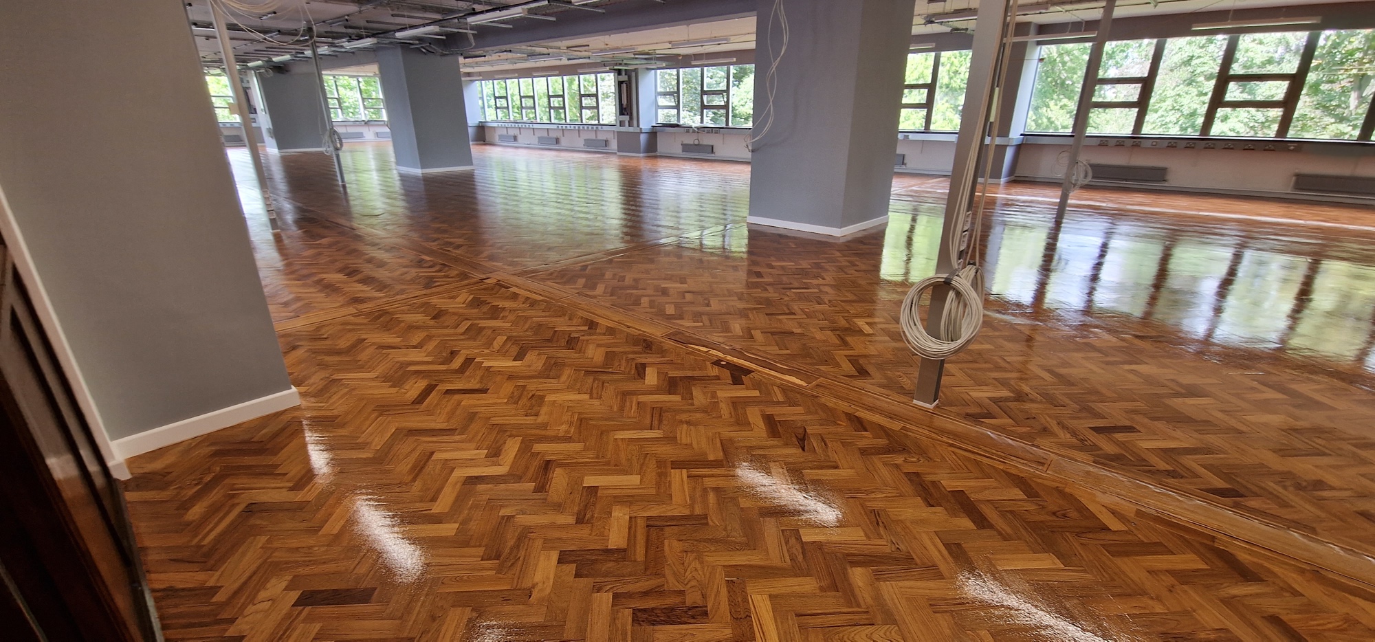 Cambridge school herringbone parquet floor after sanding, staining, and lacquering